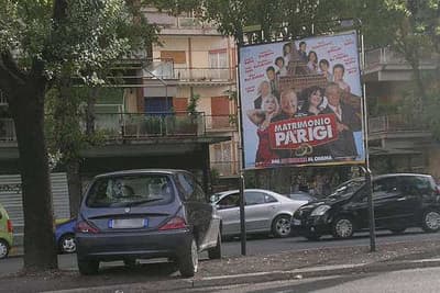 Uno stendardo con una locandina di un film all'interno di un parcheggio